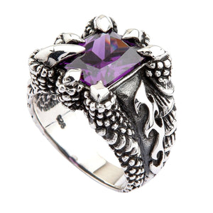 Örnklo-ring med lila kubisk zirkonia i sterlingsilver. Den fasetterade lila stenen och de böjda silverklorna visas i vinkel mot vit bakgrund.