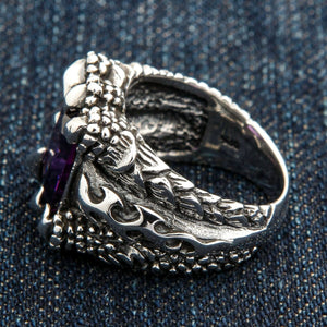 Örnklo-ring med lila kubisk zirkonia i sterlingsilver. Öppna flamformade detaljer syns under den lila stenen.