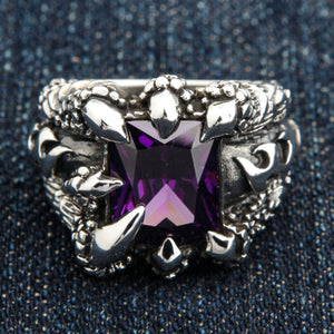 Örnklo-ring med lila kubisk zirkonia i sterlingsilver. Den lila stenen är vinklad för att visa sin fasetterade ovansida och hörnens klor.