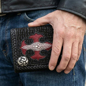 Red Stingray Cross Leather Trifold Wallet, held in hand