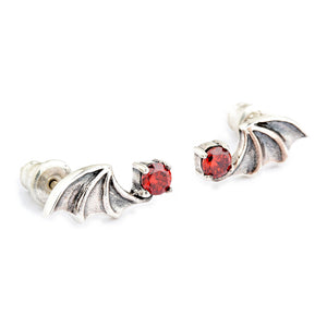 Coppia di orecchini ala di pipistrello in argento vista di sbieco, con le incastonature di zirconia cubica rossa