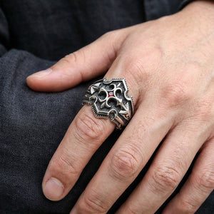 Anillo de cruz de caballero en plata de ley 925 con circonita cúbica roja, puesto en una mano