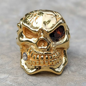 Anel de caveira em prata de lei folheada a ouro com olho vermelho, frente da caveira com olho vermelho
