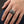Red CZ Inferno Skull Sterling Silver Ring, worn on one middle finger in a natural hand close-up