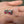 Pendientes de botón de plata de ley con ojo rojo, engastes de garras y par de ojos rojos inclinados en una mano