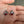 Pendientes de botón de plata de ley con ojo rojo, par de pendientes con ojo rojo vistos desde arriba en una mano
