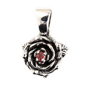 Ciondolo rosa con granato in argento sterling. Il centro in granato, i petali stratificati e la contromaglia triangolare sono mostrati in una vista frontale ravvicinata.