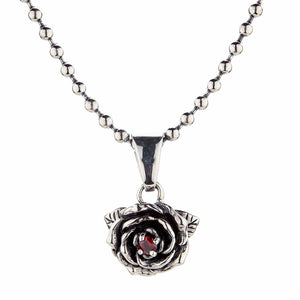 Ciondolo rosa con granato in argento sterling. Un granato rosso si trova tra i petali di rosa d'argento stratificati.