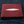 Red Pearl Stingray Bifold Wallet showing pale pearl stripe across the red front, resting on denim.
