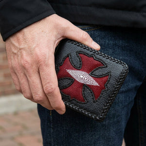 Red Stingray Cross Black Bifold Wallet, held in hand