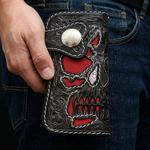 Red Stingray Demon Skull Tooled Leather Wallet, held closed at hip level