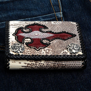 Cartera de cuero de lagarto varano con cruz de piel de raya roja que muestra el detalle del borde trenzado