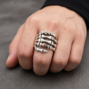 Anillo de mano esquelética de plata de ley con baño de oro rosa, lucido en una mano adulta