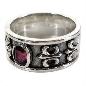 Bague bandeau en argent sterling avec fleur de lys rouge rubis, détail de la volute et de la pierre de trois-quarts gauche
