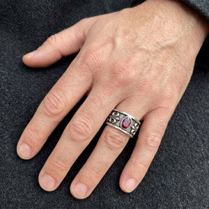 Bague bandeau en argent sterling avec fleur de lys rouge rubis portée à une main
