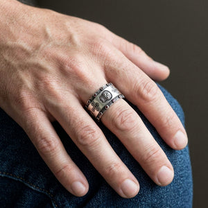 Santa Muerte Garnet Sterling Silver Band Ring, worn on one middle finger in a natural hand close-up