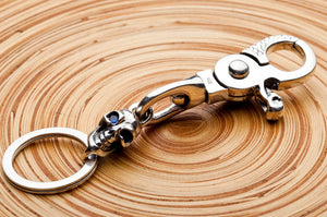 Nyckelring i sterlingsilver med dödskalle med blå safirögon, diagonal vy bakifrån av komplett nyckelring