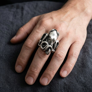 Anillo de pulpo esculpido en plata colocado en una mano