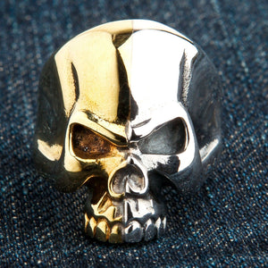 Bague demi-tête de mort en argent et laiton, de face sur denim