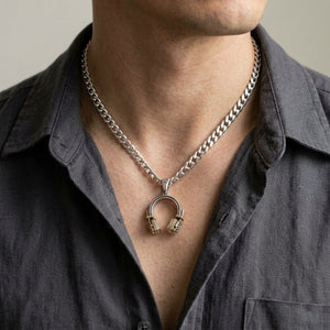 Pendentif casque audio en argent et laiton, porté sur une chaîne en argent avec une chemise anthracite ; chaîne non incluse.