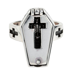 Closed coffin ring seen from the front, with a skeleton visible through the cross-shaped lid opening.