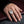 Closed cross-window coffin ring worn on a hand beside a black velvet and lace cuff.