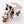 Angled view of the silver ring showing the smaller black shoulder cross beside the skull charm.