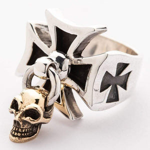 Silver cross ring viewed at an angle, with a gold-tone skull hanging below the central loop.