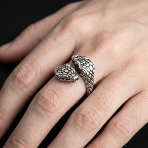 Double snake head sterling silver ring worn on a very fair-skinned hand