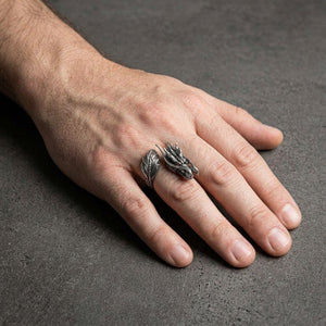 Silver Japanese dragon wrap ring with one head and one featherlike tail worn on a hand