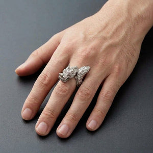 Sterling silver dragon ring with horned head and featherlike tail worn on a hand