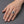 Silver and gold watch-band-style ring with oval blue CZ worn on a light-skinned hand