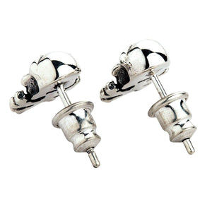 Totenkopf und gekreuzte Knochen Ohrstecker aus Sterlingsilber. Die glatten Rückseiten beider Totenköpfe sind mit ihren Steckerstiften und tonnenförmigen Verschlüssen zu sehen.