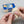 Hand using a SilverBlue cloth to polish a silver ring beside its case