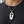 Skeleton Window Coffin Sterling Silver Locket with the skeleton visible through its cross window over a charcoal shirt.