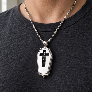 Skeleton Window Coffin Sterling Silver Locket with the skeleton visible through its cross window over a charcoal shirt.