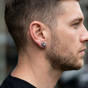 Skull crossbones silver stud worn at a male model’s ear