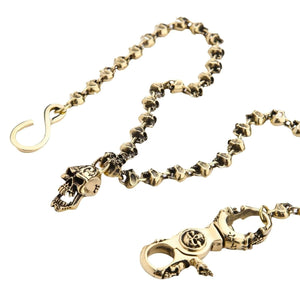 Catena da portafoglio in ottone Skull-Link, vista ravvicinata delle maglie a teschio, della chiusura e del gancio a S su sfondo bianco