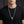 Large silver skull necklace worn on a black shirt with the clasp hidden behind the neck