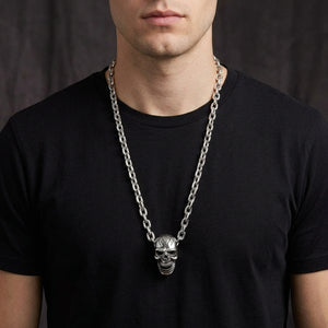 Large silver skull necklace worn on a black shirt with the clasp hidden behind the neck