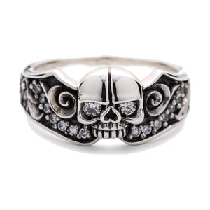 Anillo de plata de ley de calavera con ojo de diamante y volutas, anillo de calavera de frente y detalle de la calavera en relieve
