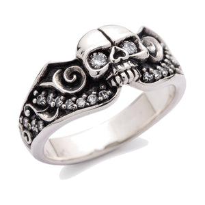 Anillo de plata de ley de calavera con ojo de diamante y volutas, vista frontal izquierda del anillo sobre fondo blanco