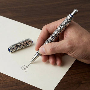Skull Carved Sterling Silver Pen, used naturally in a close-up writing scene with the decorated barrel visible