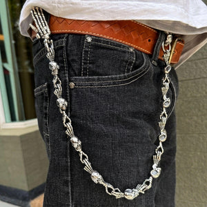 Skull and skeleton-hand silver wallet chain worn with black denim jeans