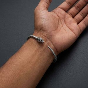 Snake Sterling Silver Adjustable Cuff Bracelet, worn palm-up on a medium-brown wrist with the open head-and-tail gap centered