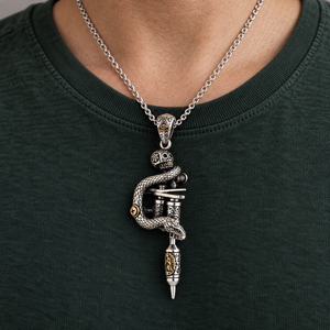 Snake and Skull Tattoo Machine Silver Pendant with coiled snake and brass details over a green shirt.