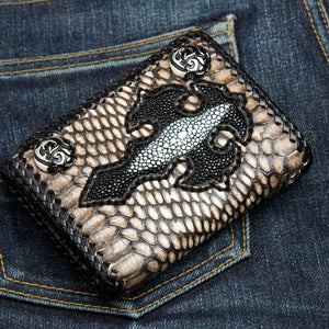 Grey snake trifold wallet laid diagonally on denim, with a black stingray cross and two flame snaps.
