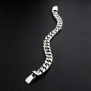 Full length view of solid silver curb chain bracelet 70 grams on dark background
