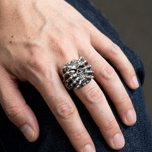 Spider Skull Sterling Silver Gothic Ring, worn on one middle finger in a natural hand close-up