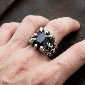 Silver gothic claw ring featuring a large rectangular black onyx gemstone held by dragon claw prongs with fleur-de-lis detail